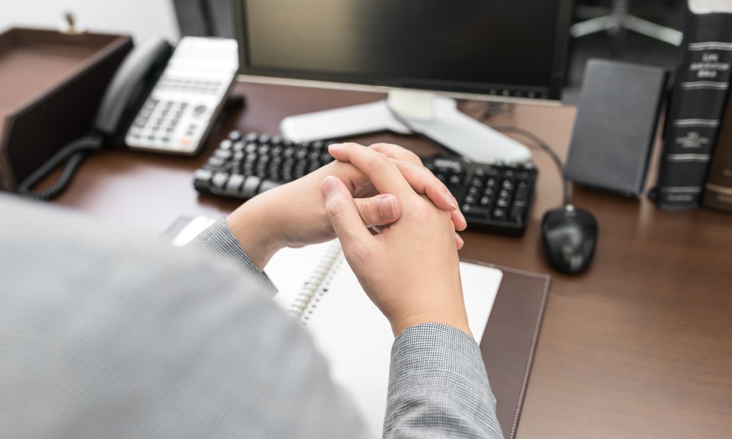 パソコンの前で手を組む男性